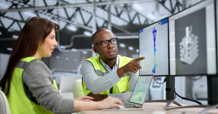 2 people in high vis vest looking at a 3d software