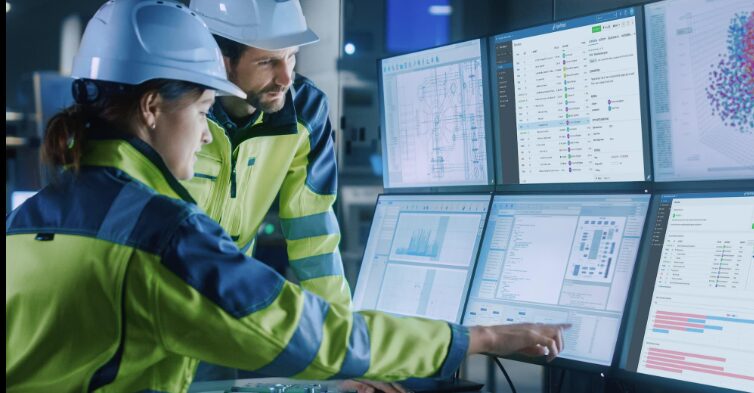 2 people in high vis jackets looking at analytics