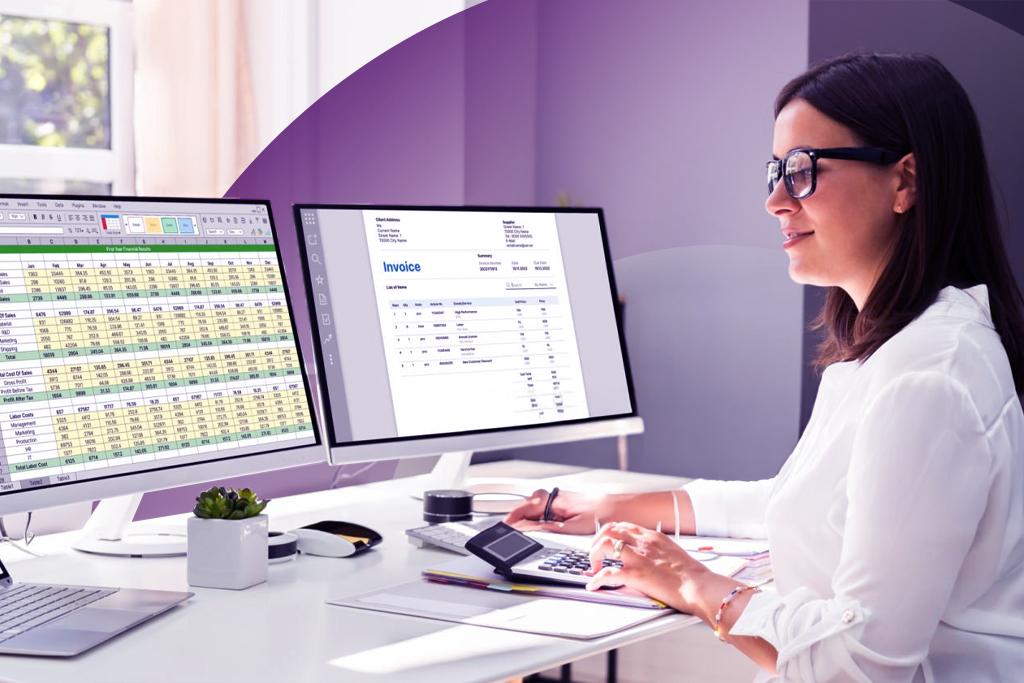 employee viewing spreadsheets on monitor with a calculator on desk
