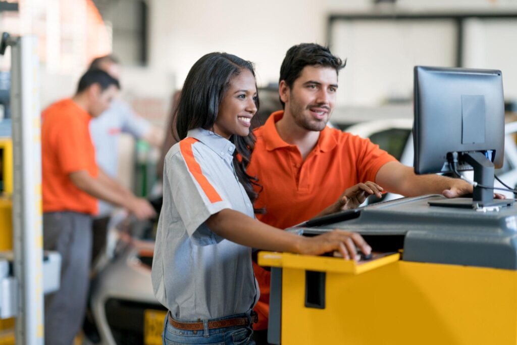 male and female mechanic stationed at a computer