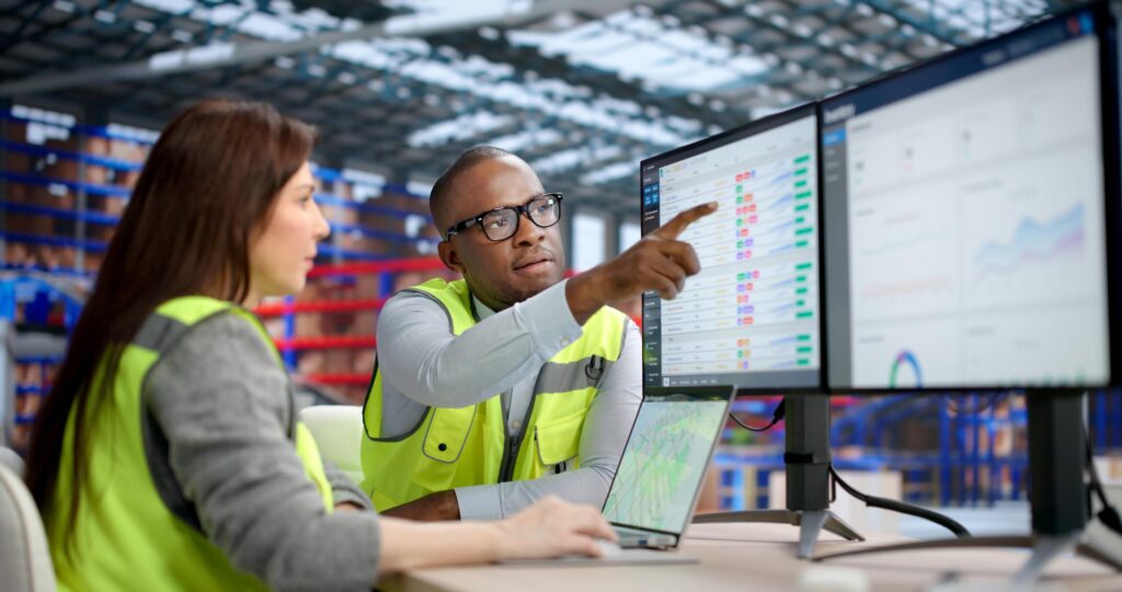 2 people in high vis looking at spreadsheets