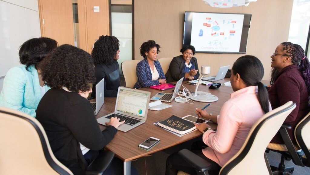 small group of staff in a meeting with a tv
