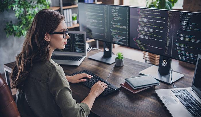 Girl working in front of multiple screens